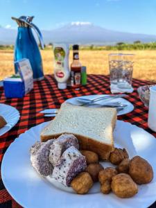 安博塞利Amboseli Cultural Camping的桌上的一块带三明治和土豆的白板