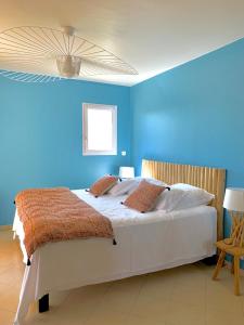 GranaceVilla U Tramontu的蓝色的卧室设有一张白色大床和蓝色的墙壁