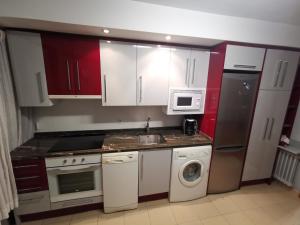 韦斯卡Cómoda vivienda en Huesca的厨房配有白色橱柜、水槽和洗碗机。