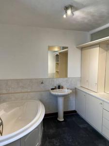 绍尔Park cottage High Crompton的白色的浴室设有浴缸和水槽。