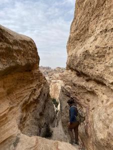 Al Jāyah7 Caves Hotel的一个人穿过峡谷