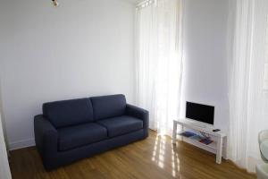 波城Quartier Historique du Château bel appt meublé的客厅设有蓝色沙发,配有电视