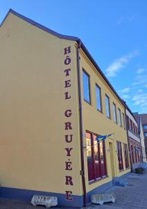 兰斯克鲁纳Sveriges minsta Hotell! Hôtel Gruyère的黄色的建筑,旁边标有标志