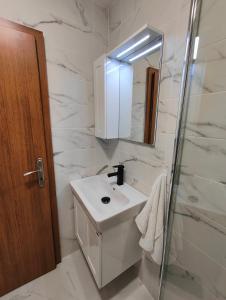 切佩拉雷Апартамент РАЯ的白色的浴室设有水槽和镜子