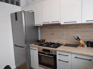 扎维尔切Apartament Gustav的厨房配有白色橱柜和炉灶烤箱。