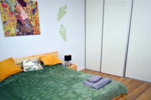 扎维尔切Apartament Gustav的卧室配有一张绿色的床,墙上挂有绘画作品