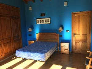 坎加斯-德奥尼斯LA LLANADA的一间卧室设有一张床和蓝色的墙壁