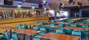 阿贝尔格莱Kens caravan的一间空餐厅,配有桌椅,酒吧