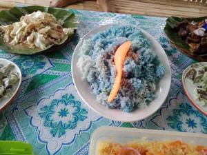 BatuanJolits Ecogarden Integrated Farm的一张桌子,上面放着一碗米饭和胡萝卜