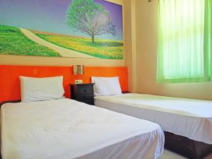 NunukanOYO 92126 Hotel Syariah Sumber Mulya Nunukan的墙上画画的房间里设有两张床