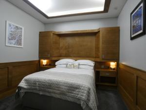 奥本Lorne View的一间卧室配有一张大床和木制床头板
