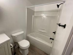 温尼伯Home away from home的白色的浴室设有卫生间和浴缸。
