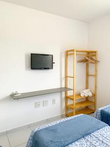 德奥多鲁元帅镇Casa Iva - Condomínio Fechado的卧室配有一张床,墙上配有电视。