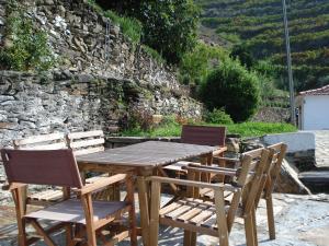 阿利若Country house Quinta da Salgueira的一张木桌、两把椅子和石墙