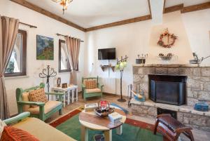 阿拉霍瓦Arachova "Villa Dianne"的客厅设有石制壁炉和绿色椅子