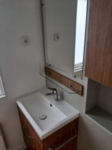 东卡佩勒Chalet DIE SONNE的浴室设有白色水槽和镜子