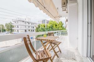 雅典Glyfada's Central Apartment的阳台配有两把椅子和一张桌子