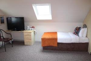 阿马山景旅馆的一间卧室配有一张床和一张书桌及电视