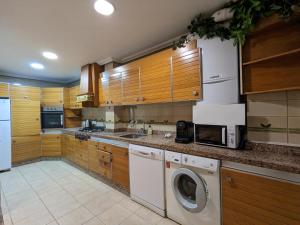 埃尔切Comunidad Valenciana 31的厨房配有木制橱柜、洗衣机和烘干机