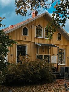 VarnhemKlostergårdens Vandrarhem的黄色房子,前面有标志