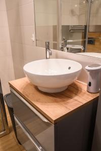 华沙Marywilska apartment的木制柜台上带白色碗水槽的浴室