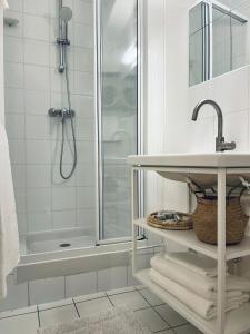 巴黎Chic Apartment on the famous shopping Rue du Faubourg Saint-Honoré street的带淋浴和盥洗盆的白色浴室