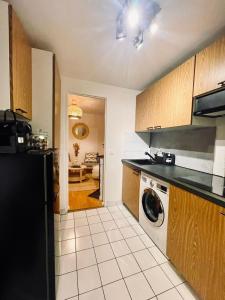 巴黎Chic Apartment on the famous shopping Rue du Faubourg Saint-Honoré street的厨房配有黑色冰箱和洗碗机。