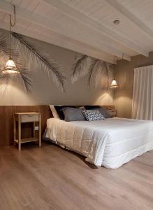 科尔多瓦Casa Onas Hotel Boutique Córdoba的卧室配有白色的床和棕榈叶壁画