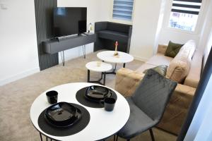 比托拉Magnolija Apartments的客厅配有两张桌子和一张沙发