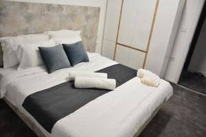比托拉Magnolija Apartments的一张大床,配有黑白床单和枕头