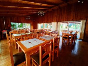 普孔La Casona Caburgua的用餐室配有木桌和椅子