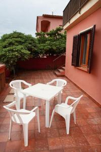 罗萨岛迪默黛尔伊索拉罗萨公寓的庭院里配有一张白色的桌子和两把椅子