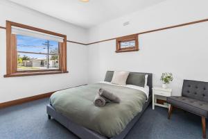 Geelong WestCharming Cottage Escape - Pet friendly!的一间卧室设有一张床、一个窗口和一把椅子