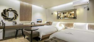 全州市Jeonju NEUE Hotel的酒店客房设有两张床和一个带镜子的梳妆台