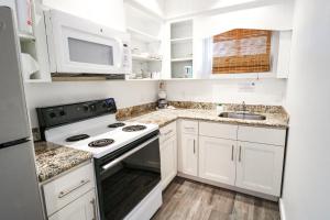 伊斯拉莫拉达Drop Anchor Resort & Marina的白色的厨房配有炉灶和微波炉。