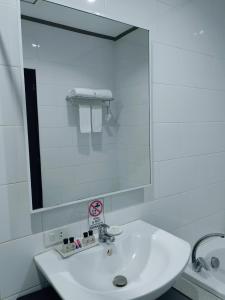 八打雁八打雁乡村俱乐部酒店的白色的浴室设有水槽和镜子