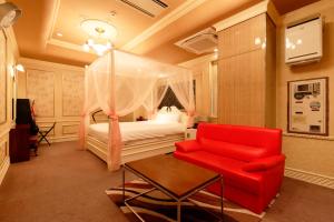 伊豆之国市HOTEL555 伊豆長岡的一间卧室配有一张床和一张红色椅子