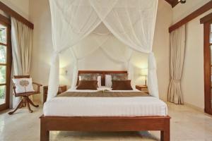 塞米亚克阿鲁利马别墅的一间卧室配有带窗帘的天蓬床