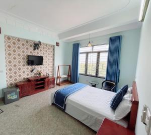 宁平Tam Coc Guest House & Hostel的一间卧室配有一张大床和电视