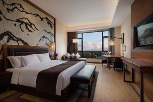 安图县长白山温泉皇冠假日度假酒店的酒店客房设有一张大床和一张书桌。