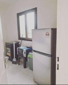 瓦加杜古Appartement luxueux ouaga2000(2 chambres )的厨房配有白色冰箱和炉灶。