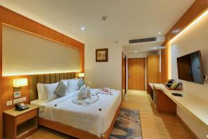 班加罗尔Clarion Hotel Bangalore的酒店客房,配有床和电视