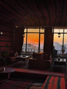 瓦迪穆萨洛矶山酒店 的带沙发的客厅,享有日落美景