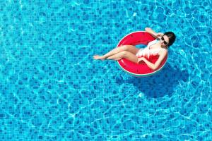 曼谷伯莱尔曼谷酒店  SHA Extra Plus的坐在游泳池里红圈上的女人