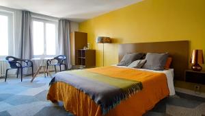 康卡勒Kêr L - Breizh & Breakfast的一间卧室设有一张大床和黄色的墙壁