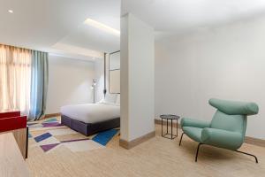 塞卡凯Ewaa Express Hotel - Al Jouf的酒店客房,配有一张床和一张蓝色椅子