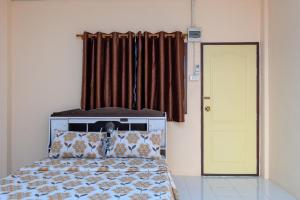 Ban Laem BuaBeung Sampathuan Nakornchaisri Resort的一间卧室设有一张床和一个黄色的门
