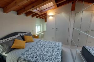 明乔河畔的瓦雷奇奥Sui Tetti di Valeggio - Holiday Apartment的一间带一张床的卧室,位于带木制天花板的房间内