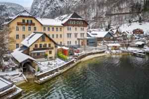 哈尔施塔特Hallstatt Lakeside Top 2 - Zimmer mit Gartenzugang的积雪覆盖的建筑和水体的城镇