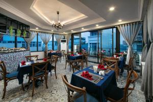 河内San Boutique Hotel的餐厅设有蓝色的桌椅和窗户。